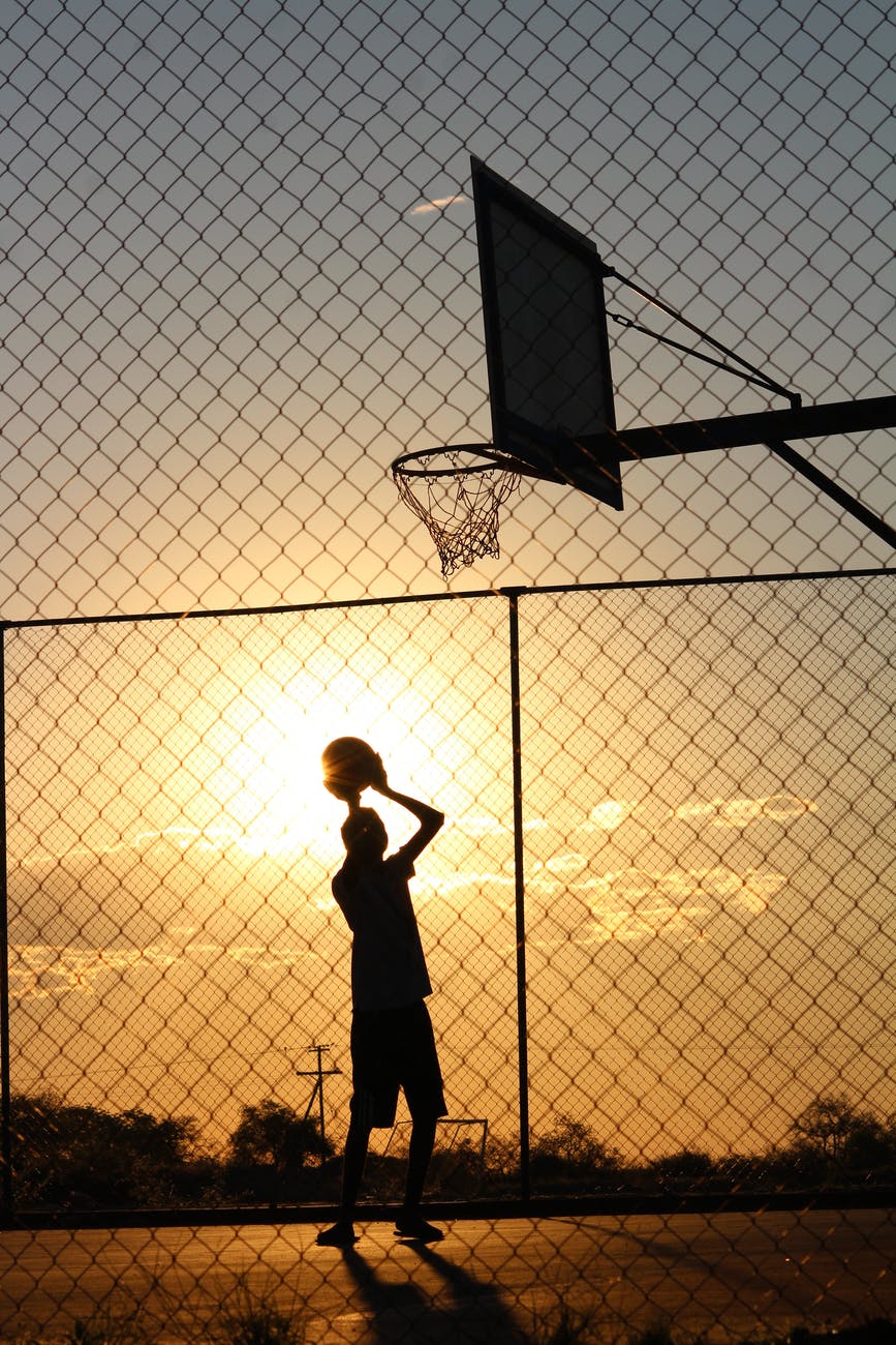 basketball player throwing ball into basketball hoop