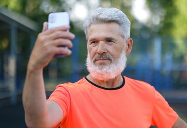 serious aged man taking selfie on smartphone