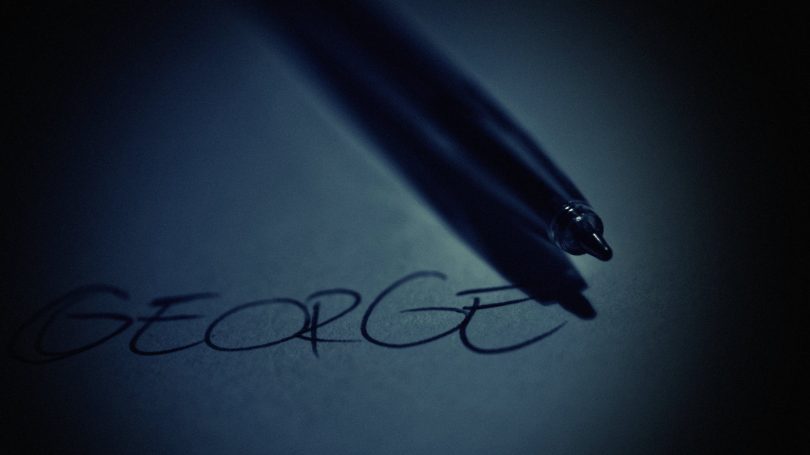 black pen on top of white paper with george text