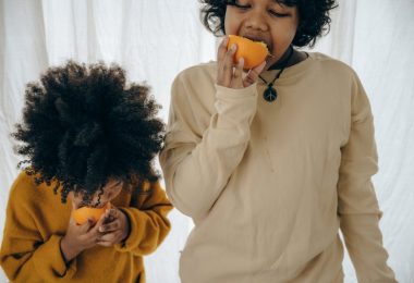 hungry ethnic kids with fresh fruit in studio