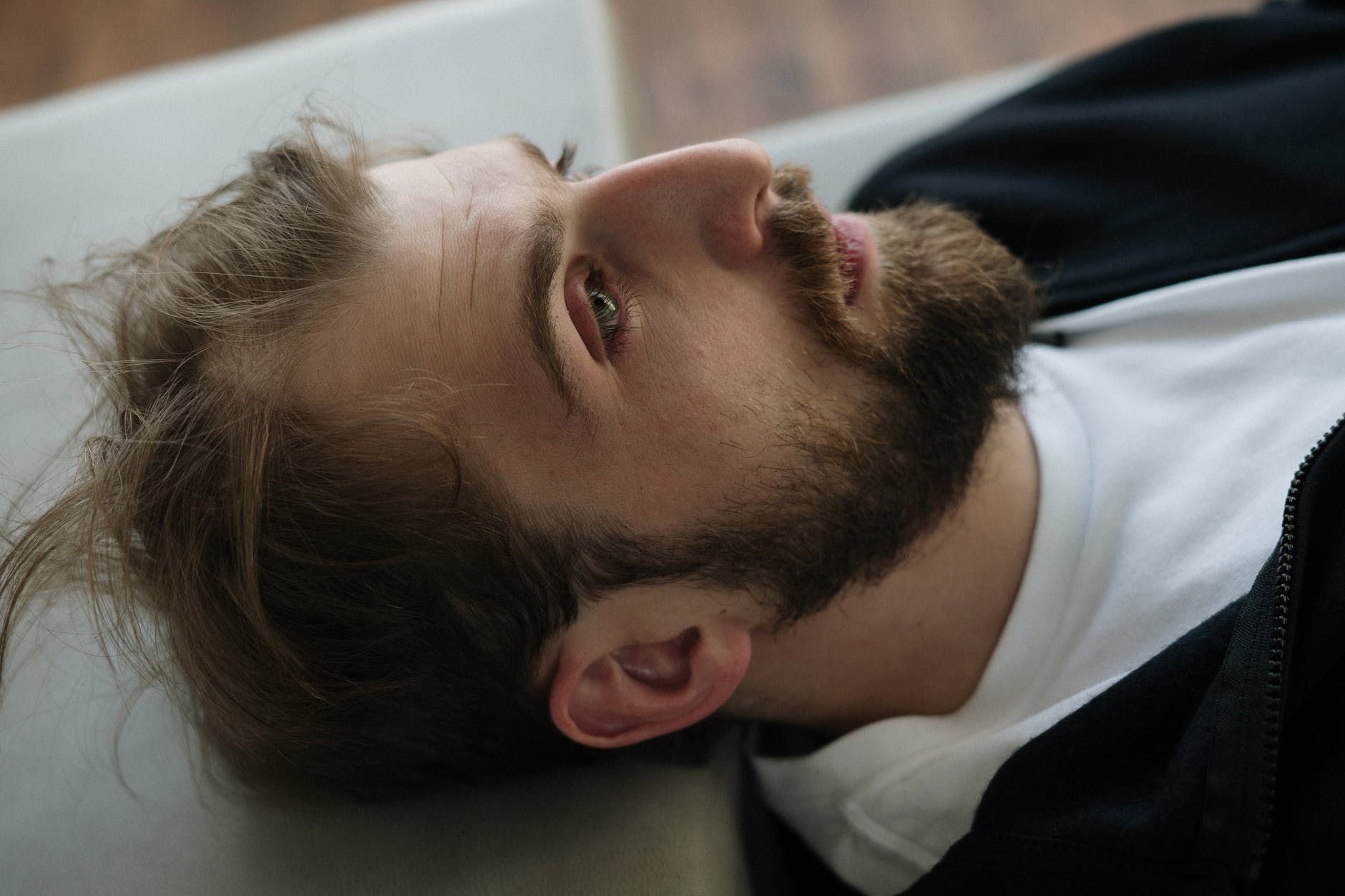 man in black and white shirt lying on bed