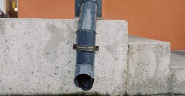black pipe on concrete wall