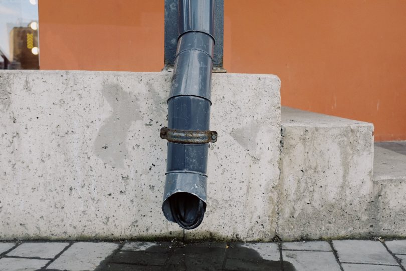 black pipe on concrete wall