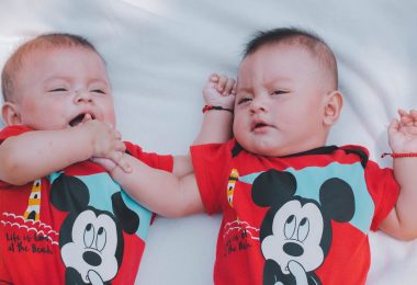 two babies wearing red mickey mouse shirts