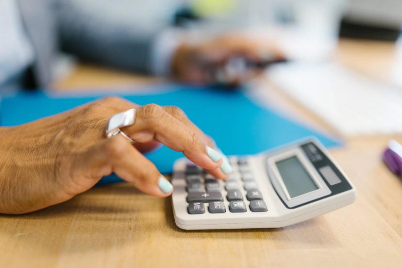 person holding gray desk calculator
