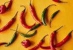 red and green peppers on yellow background