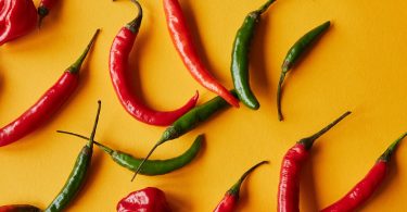 red and green peppers on yellow background