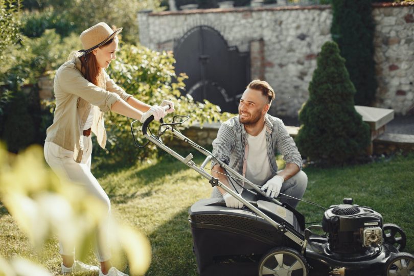 woman in brown long sleeve shirt holding grass cutter