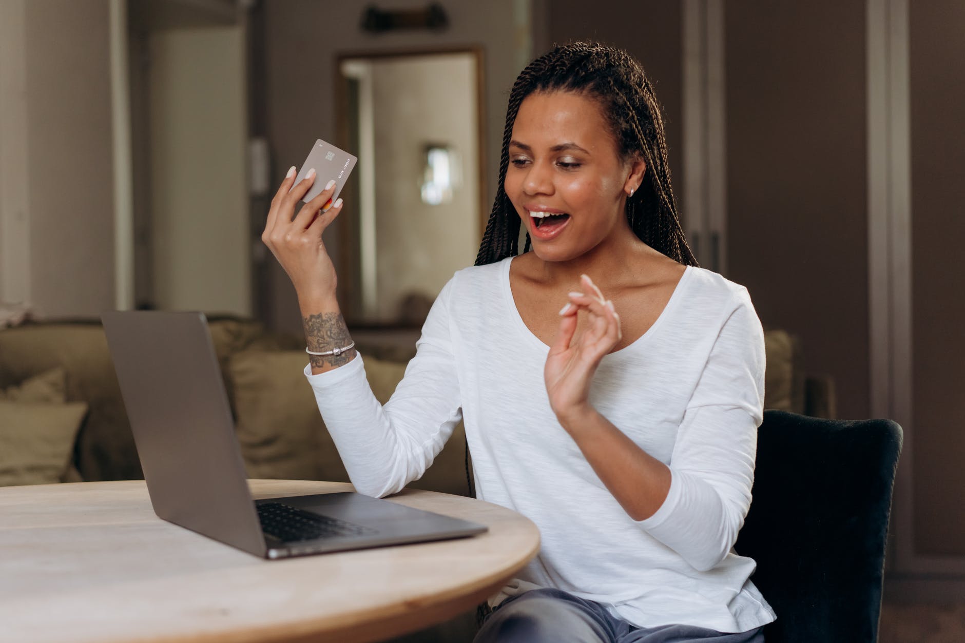 woman in white long sleeve shirt holding brown credit card