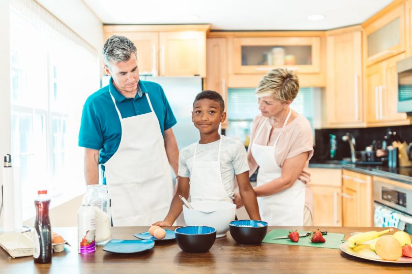 couple with their adopted child in the kitchen
