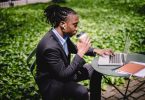 focused black businessman working on laptop in park