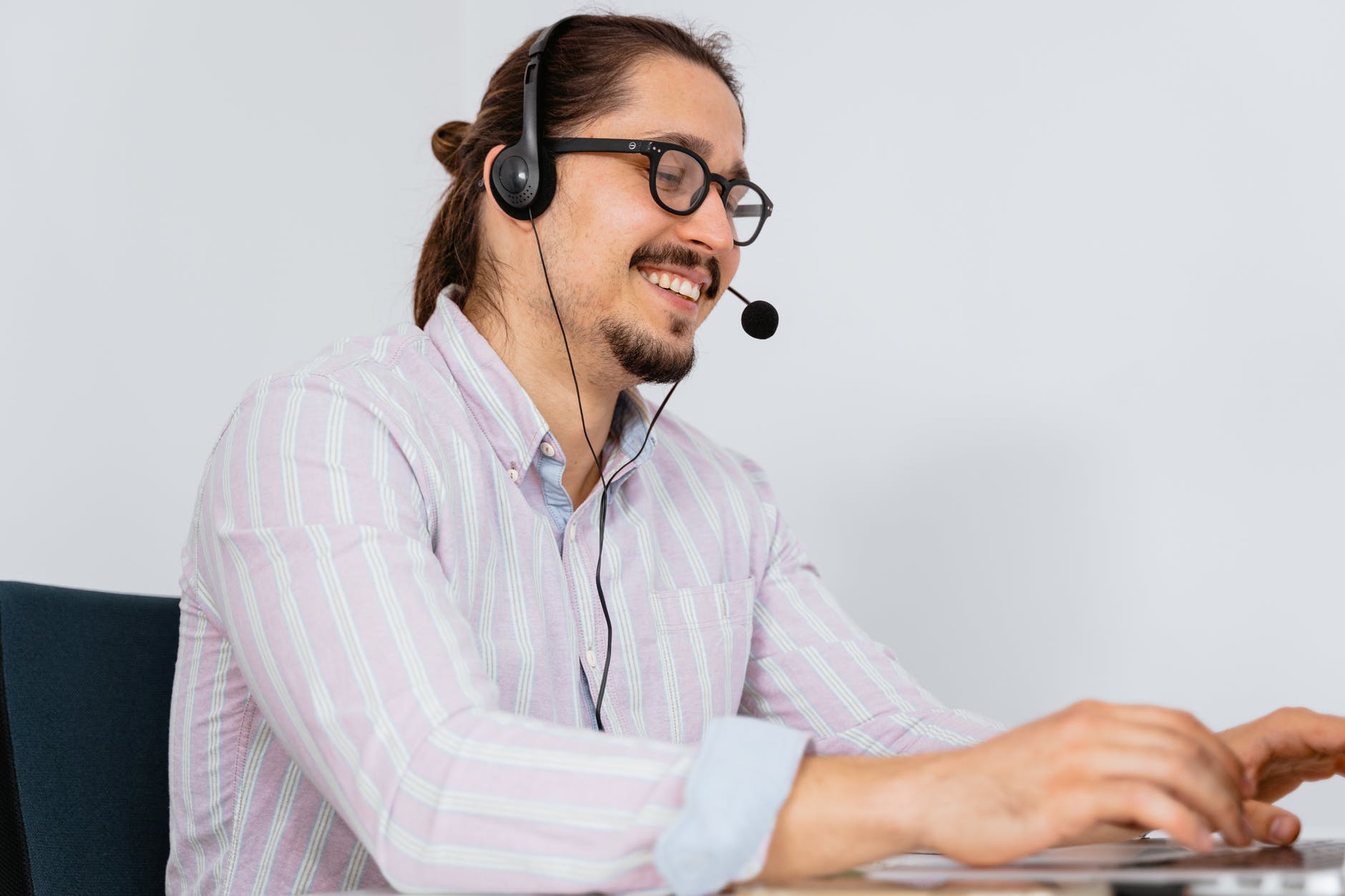 man in long sleeve shirt with black headset and mouthpiece