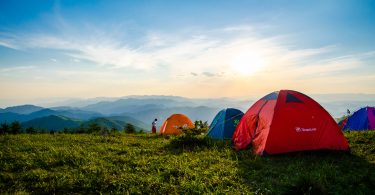 Photo of pitched dome tents overlooking mountain ranges