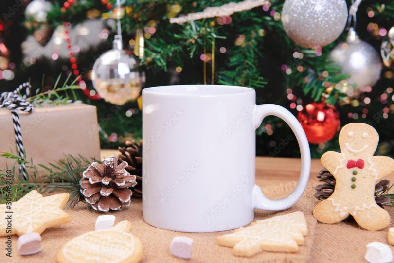 White ceramic coffee cup and christmas decoration on woon table background. mockup for creative advertising text message or promotional content.