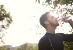 Man in black crew neck shirt drinking water