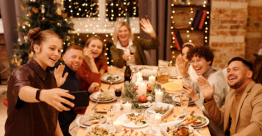 Family celebrating christmas dinner while taking selfie