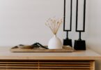 white ceramic vase near two black table decors
