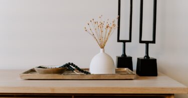 white ceramic vase near two black table decors