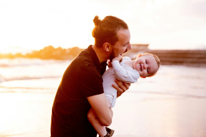 Father and baby on the beach at sunset