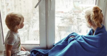 two children sitting near the window and communicate with each other