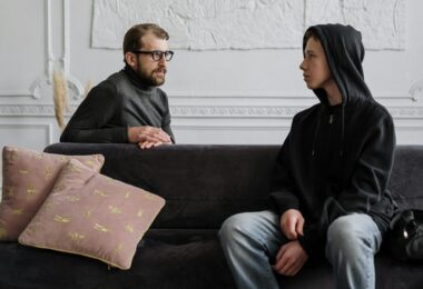 Man in black jacket sitting on couch