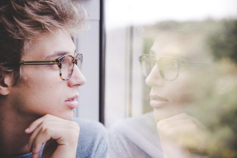 man looking out window