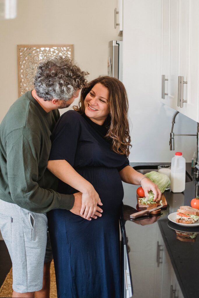 pregnant-couple-embrace-kitchen